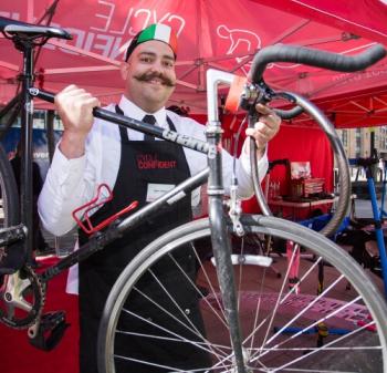Man holds bike in air and smiles