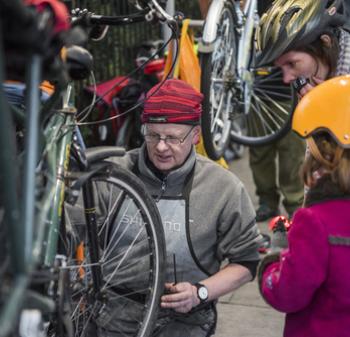 Bike mechanic fixes bike for child