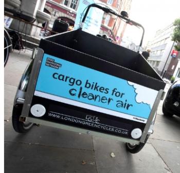 black cargo bike with blue sign on it saying 'cargo bikes for cleaner air' with ZEN logo and logo from London Green Cycles